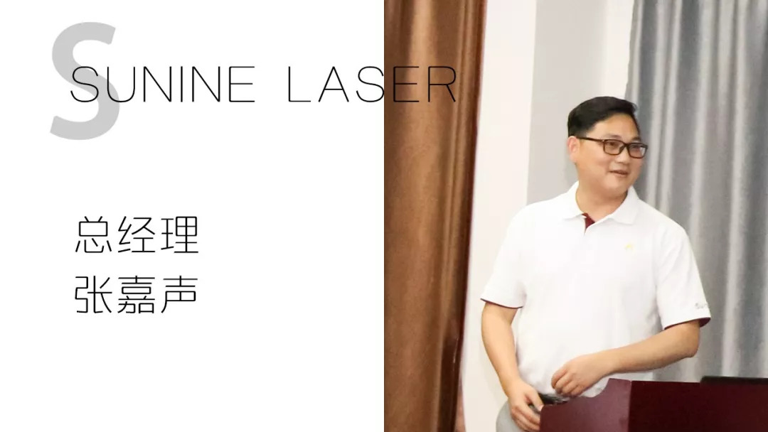 戴眼镜男子站在讲台后，旁佑装总经理 张嘉声”文字