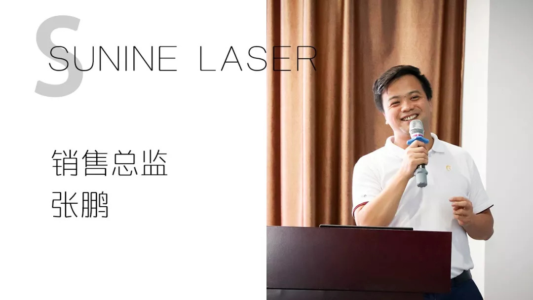 男子持麦克风站在讲台后，旁佑装销售总监 张鹏”文字