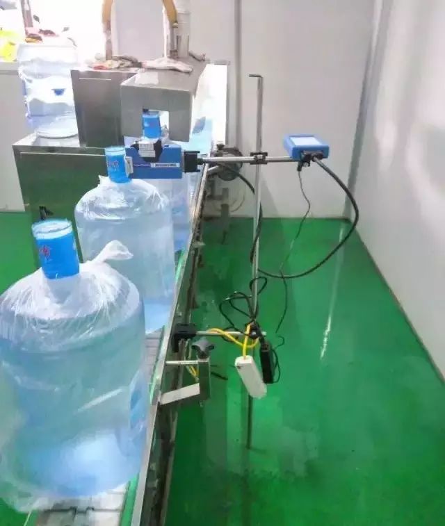 成排大号水桶、输送链及表侧蓝色设备支架