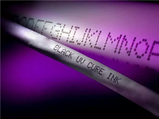 两根淡色线缆上的点阵字母及BLACK UV CURE INK文字