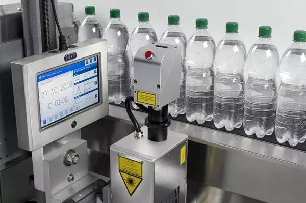 绿盖通明瓶输送线旁的LINX节造屏与带警示标签设备