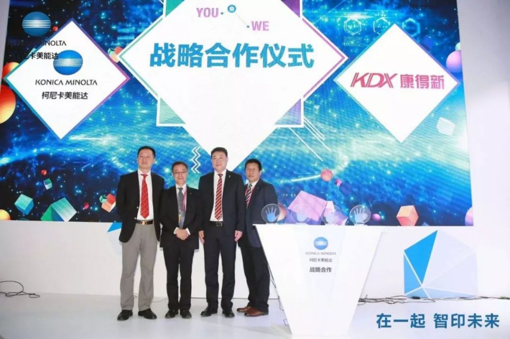 www.eamar_.com_.cn-news984123810-1024x682 四名男子在柯尼卡美能达与KDX康得新标志布景前合影