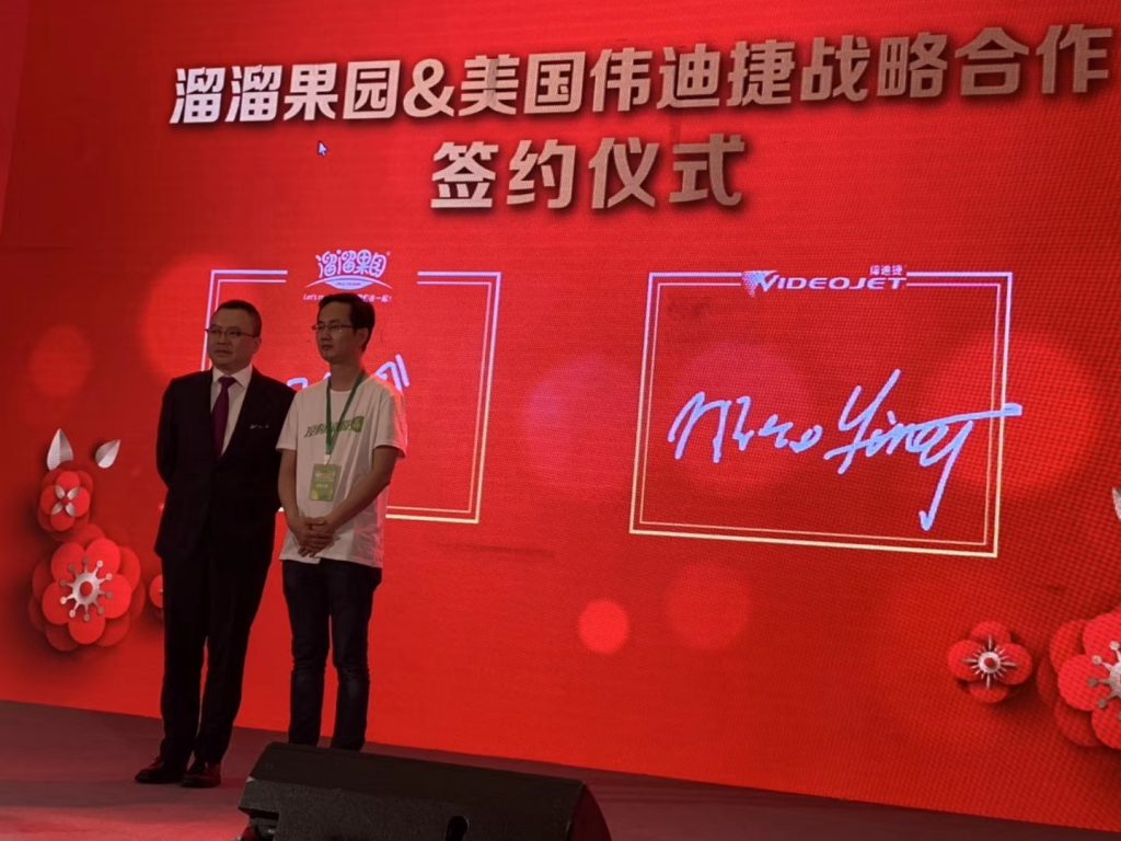 IMG_1504-1024x768 两人在溜溜果园与伟迪捷战术合作签约典礼布景前合影