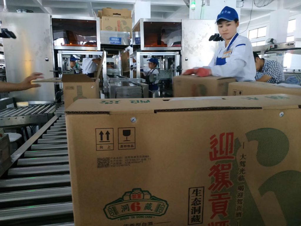 滚筒输送线上迎驾贡酒纸箱及旁边工作人员