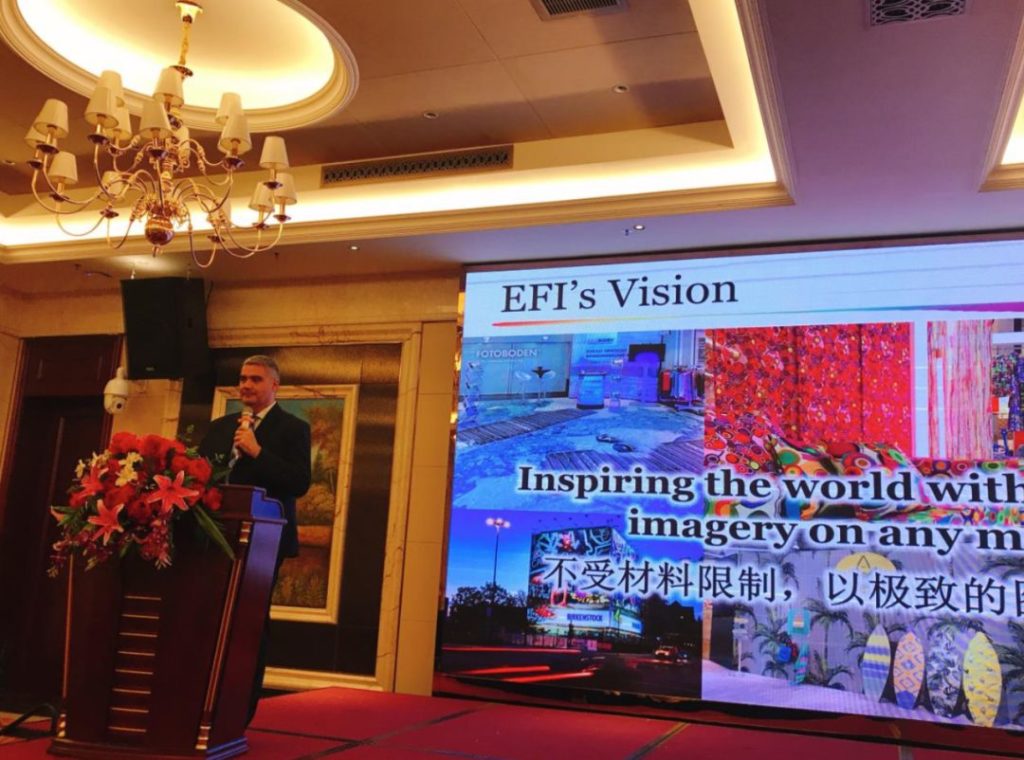 演讲者站在EFI’s Vision投影画面旁