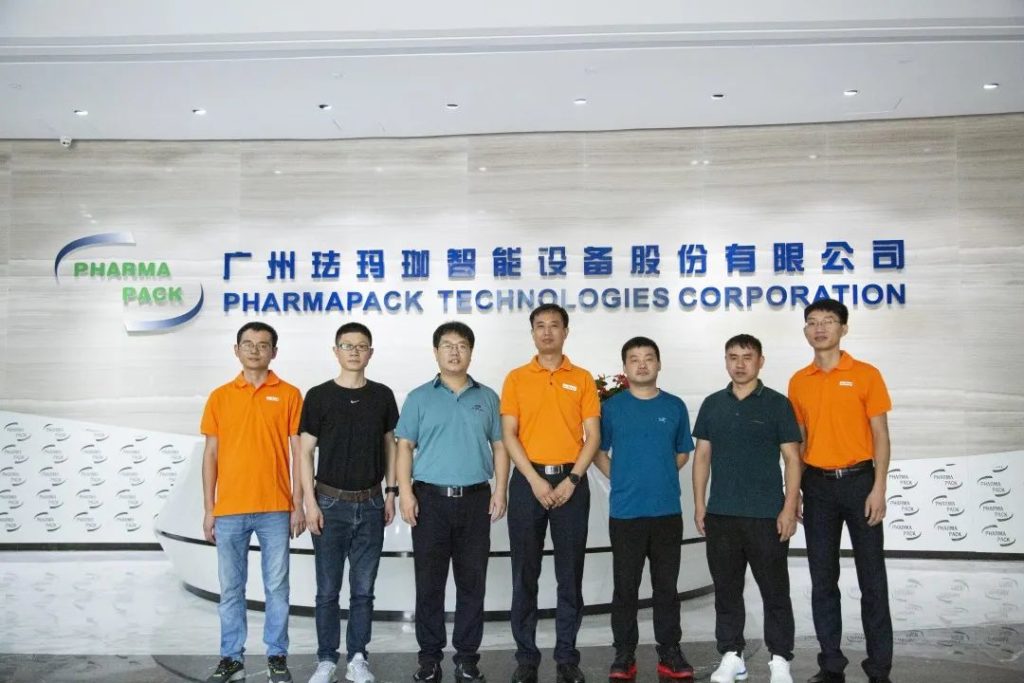 七人站在昭通珐玛珈智能设备股份有限公司标识墙前合影